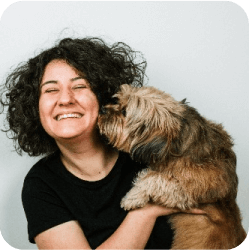 A dog affectionately kissing its trainer at Doggies Gone Wild in Miami Gardens, illustrating the close and loving relationship between our pets and their caregivers.